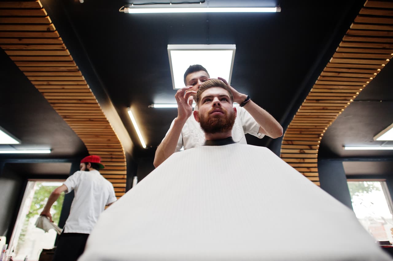 Barbería atendiendo a un cliente